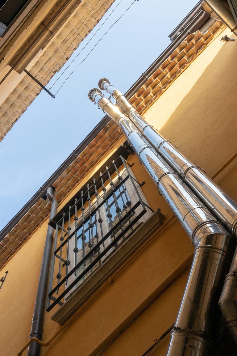 Descentes d'eaux pluviales le long d'une façade enduite